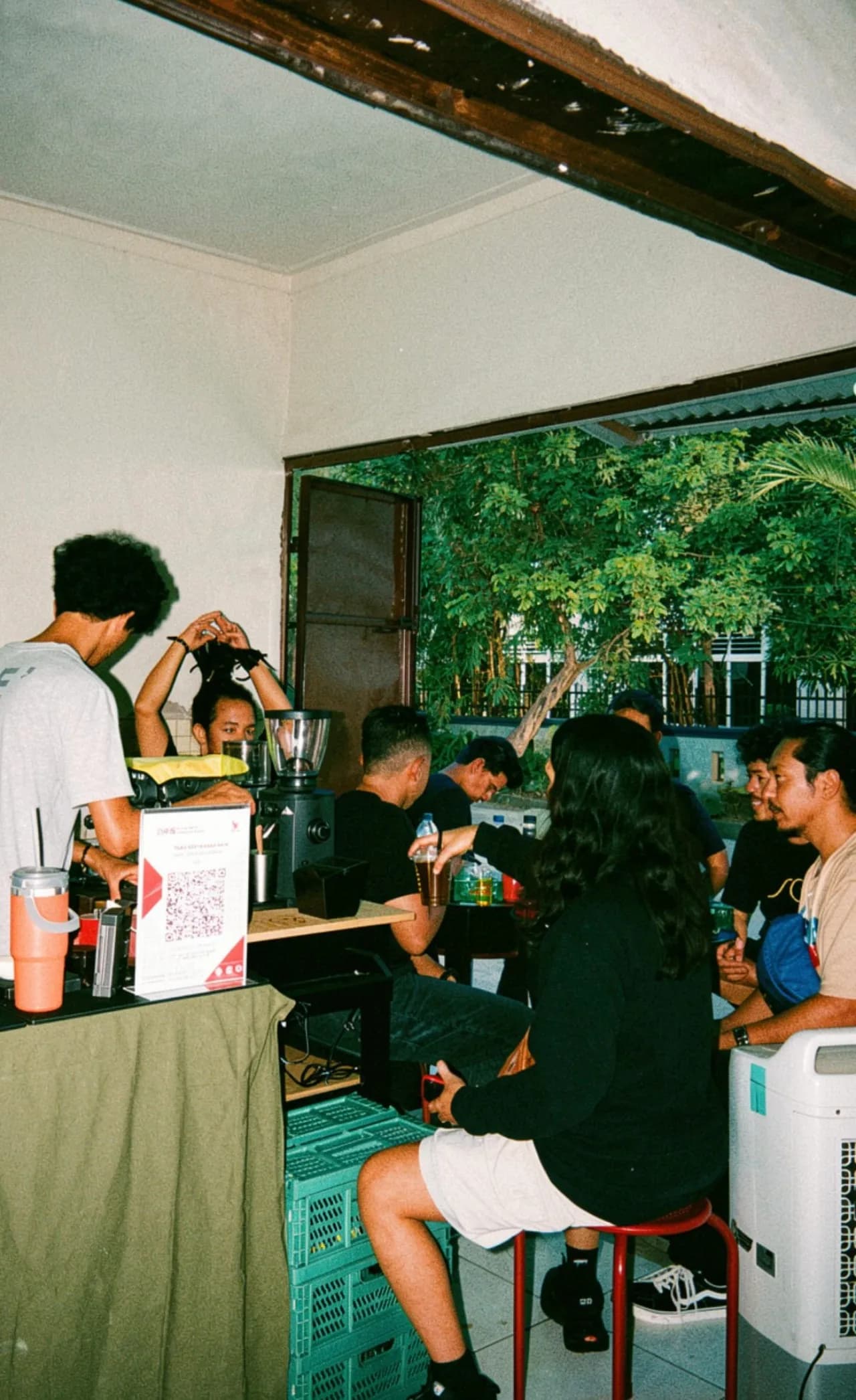 Bar barista dengan grinder dan mesin espresso, tamu duduk dekat counter